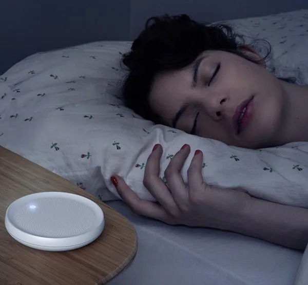 The Dodow sleep aid device on a nightstand, projecting blue light onto the ceiling